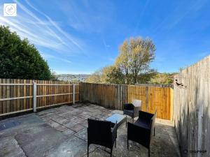 un patio con 2 sillas, una mesa y una valla en Alder House - Dowlais, en Dowlais