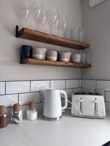 Una encimera de cocina con una tostadora y una tetera. en Alder House - Dowlais, en Dowlais