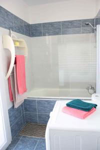 a bathroom with a tub and a shower with towels at Le Cocon Niçois Studio Cozy et Lumineux avec Parking in Nice
