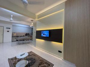 ein Wohnzimmer mit einem Fernseher an der Wand in der Unterkunft Willow Whisper 3 ROOMS by EZYHOME MELAKA in Ayer Keroh