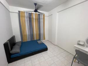 ein kleines Schlafzimmer mit einem blauen Bett und einem Fenster in der Unterkunft Willow Whisper 3 ROOMS by EZYHOME MELAKA in Ayer Keroh