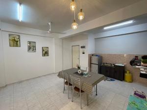 ein Wohnzimmer mit Tisch und Küche in der Unterkunft Willow Whisper 3 ROOMS by EZYHOME MELAKA in Ayer Keroh