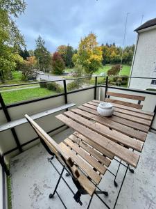 a wooden table and a chair on a balcony at Comfort Meets Simplicity 2BR Apartment in Zürich