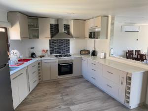 a kitchen with white cabinets and a black refrigerator at Casa con vista lago Rapel in Las Cabras