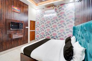a bedroom with a bed and a tv on a wall at Hotel O Divya in Bilāspur