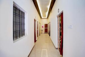 a corridor of a building with white walls and windows at Hotel O Divya in Bilāspur