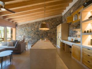 a kitchen and living room with a stone wall at Casa rural, de estilo moderno, en gran canaria in Taidía