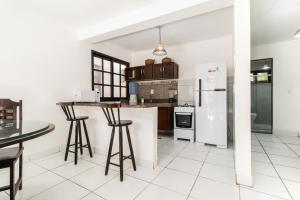 a kitchen with white tile floors and white appliances at Cond Vista Hermosa - Casas para famílias 2 quartos in Pipa +32 photos