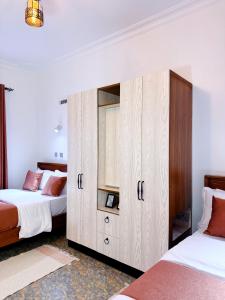 a bedroom with two beds and a large cabinet at Five-Eight Residences in Jinja
