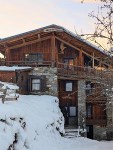 a log cabin with a deck in the snow at Chalet MontBlanc in La Plagne Tarentaise