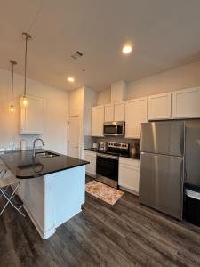 a kitchen with white cabinets and a stainless steel refrigerator at Pleasant apartment in Austin in Leander