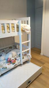 ein weißes Etagenbett mit offenem unteren Regal in der Unterkunft Chez YEP in Anzin-Saint-Aubin