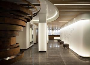 Un pasillo con sillas y una escalera en un edificio. en NH Madrid Chamberí, en Madrid