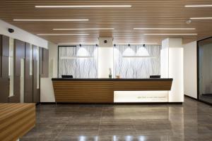 un vestíbulo de oficina con recepción y ventanas en NH Madrid Chamberí, en Madrid 29 fotos más