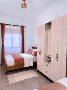 - une chambre avec 2 lits et une grande armoire dans l'établissement Five-Eight Residences, à Jinja