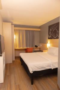 a hotel room with a bed and a television at ibis Catanduva in Catanduva