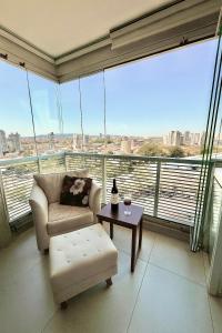 a living room with a couch and a table and large windows at 74m2 Centro, Osasco, 500m da estação, 5 minutos Super Shopping in Osasco