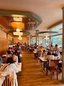 un grupo de personas sentadas en mesas en un restaurante en Beatenberg Resort & Spa in Beatenberg Interlaken, en Beatenberg