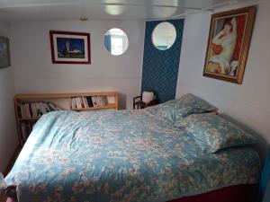 Un dormitorio con una cama con edredón azul y dos ventanas. en bateau Escapade, en Ramonville-Saint-Agne