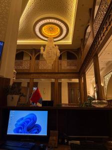 a room with a computer monitor and a chandelier at Oldtown1111 in Samarkand