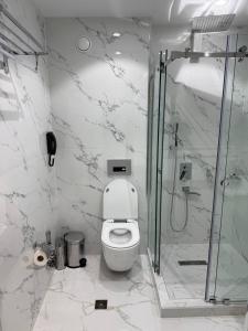 a white bathroom with a toilet and a shower at Oldtown1111 in Samarkand