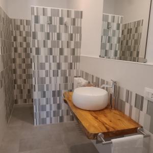 a bathroom with a white sink on a wooden counter at B&B Il Palazzo in Bassano Romano
