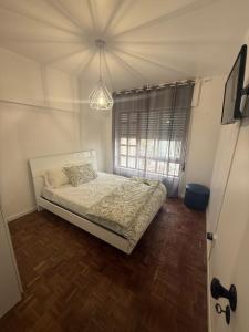 Un dormitorio con una cama y una lámpara de araña. en Apart Lisbon Airport, en Lisboa