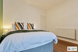 a bedroom with a large bed with white sheets and pillows at Becky's House: Near Motor Point Arena with Free Parking in Nottingham