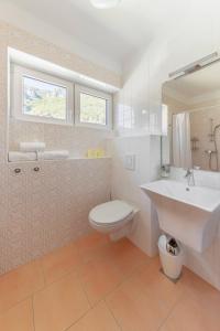a white bathroom with a sink and a toilet at doLodge homestead in the Kolpa River canyon in Stari Trg ob Kolpi