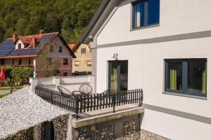 a balcony of a white building with a bench on it at doLodge homestead in the Kolpa River canyon in Stari Trg ob Kolpi