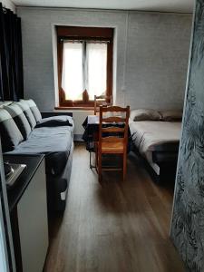 a room with two beds and a couch and a table at Le studio à la campagne in Saint-Gobert