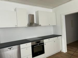 a kitchen with white cabinets and a black counter top at Nina Ferienwohnungen in Bad Fallingbostel