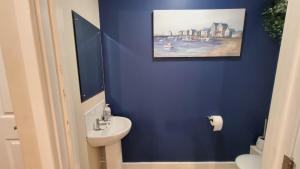 a blue bathroom with a toilet and a sink at Stylish 2-bedroom home in Salford - 5 guests in Manchester +2 photos