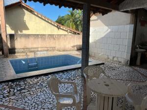 a patio with a table and chairs and a swimming pool at Casa Bem-Te-Vi | Alter do Chão in Alter do Chao