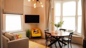 a living room with a dining room table and chairs at The Garden Room YORK in York +3 photos