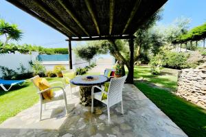 a patio with a table and chairs under a gazebo at Alojamientos Nacarum in El Palmar