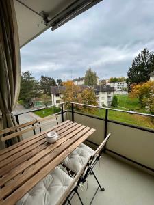 een houten tafel op een balkon met uitzicht bij Comfort escape on Schwandenwiesen in Zürich