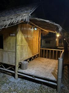 ロッブリーにあるมีสุข ฟาร์มสเตย์の夜の木製デッキのある小さな小屋