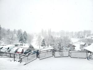 une cour enneigée avec des voitures enneigées dans l'établissement Location Paradiski San Bernardo, à Séez