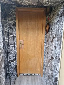 una puerta de madera en un muro de piedra en Zimmer 3 mit eigenem Bad & Eingang nähe Barmstedt Elmshorn, en Bokholt-Hanredder