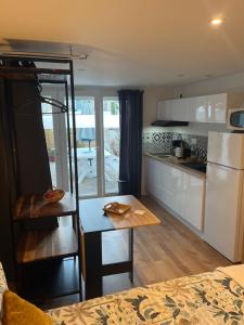Una pequeña cocina con una mesa y un refrigerador. en Ele STUDIO indépendant, en Bergerac 3 fotos más