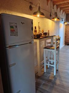 a kitchen with a white refrigerator and a table at Vinoteca cerro in Piriápolis