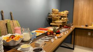 ジョアンペソアにあるJardins Almare Apart Hotelのテーブルの上にフルーツやその他の食べ物が並んだビュッフェ