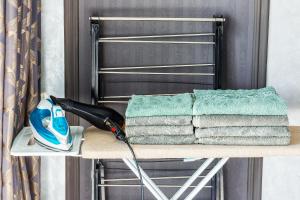 a pile of towels on a drying rack with a blow dryer at Modern Stroy 55 by Royal Rentals in Yunusobod +24 photos