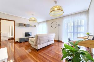 Una sala de estar con un sofá y un televisor. en Acogedor apartamento en Gernika, en Guernica y Luno