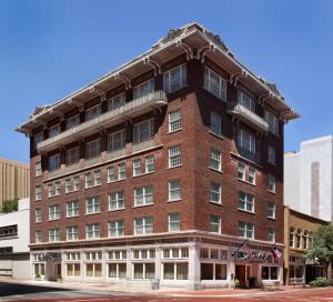 a large red brick building on a street at The Ashton Hotel in Fort Worth