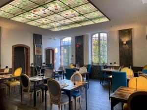 a restaurant with tables and chairs and a stained glass ceiling at Château de Loubéjac in Montauban