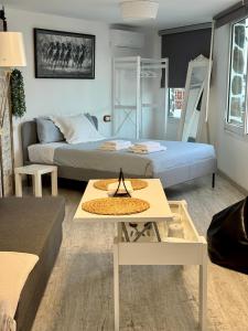 a living room with a bed and a table at La Posada del Bonsai in Rincón de la Victoria +19 photos