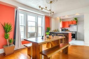 a kitchen with orange walls and a wooden table at Prime Location Top Rated Clean Parking Free! in Columbus