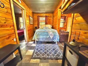 Un dormitorio con una cama en una cabaña de madera. en Mossback, en Wright City